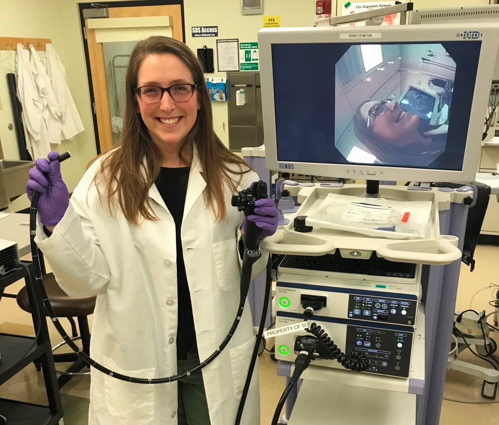 Photo of Amanda Smith standing in front a medical device. 