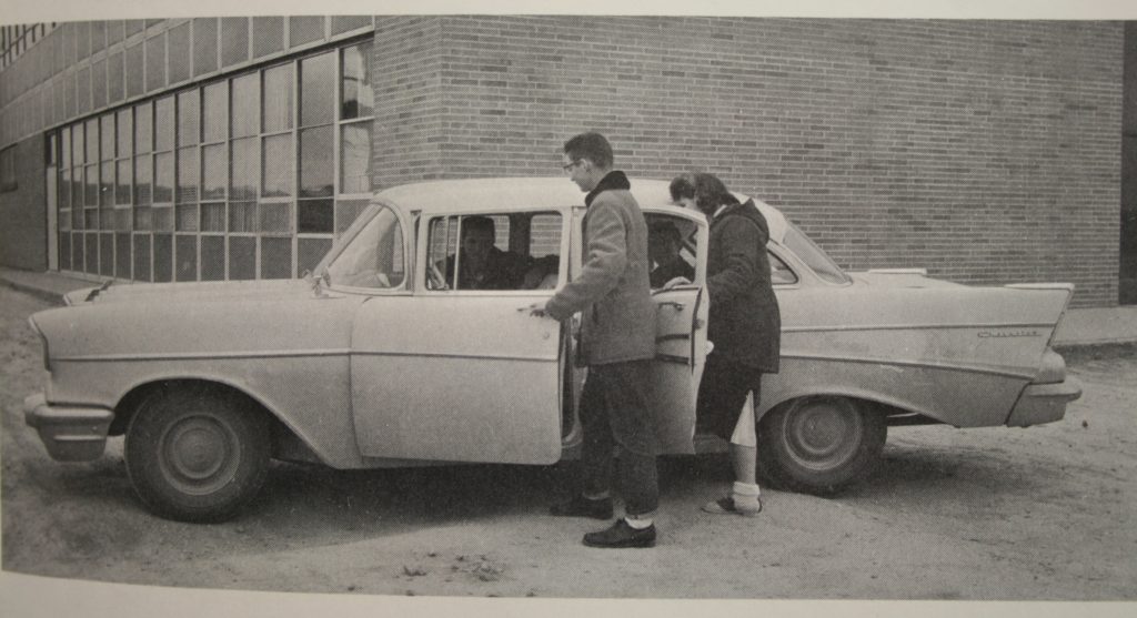 Two students in 1959 getting into a four door car.  